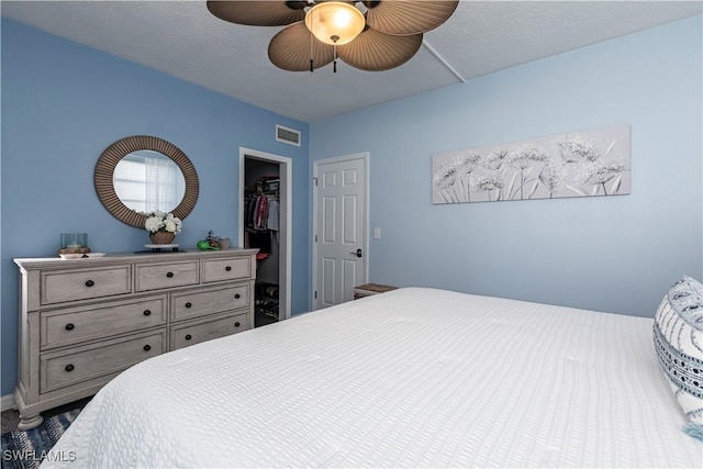 bedroom with ceiling fan, a walk in closet, and a closet