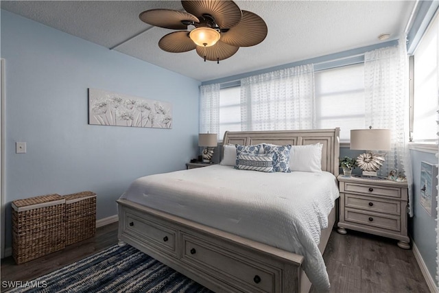 bedroom featuring ceiling fan, dark wood-type flooring, and a textured ceiling