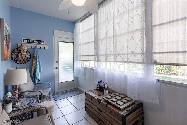 living area with light tile patterned flooring and ceiling fan