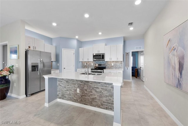 kitchen featuring white cabinetry, sink, an island with sink, and appliances with stainless steel finishes