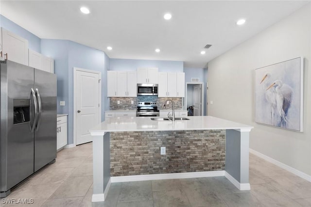 kitchen featuring sink, white cabinetry, tasteful backsplash, a center island with sink, and appliances with stainless steel finishes