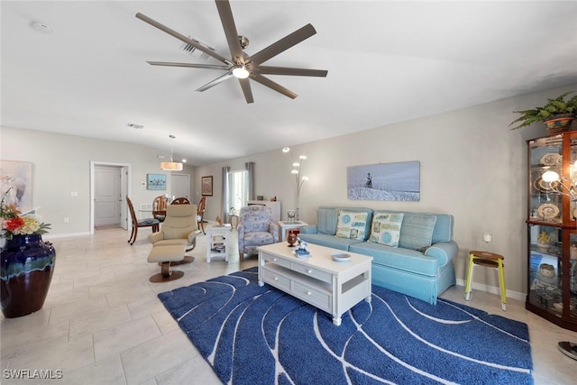 living room featuring ceiling fan, vaulted ceiling, and light tile patterned floors