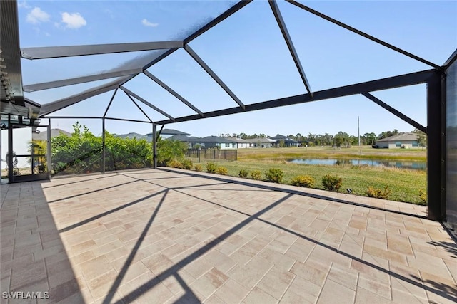 view of patio featuring a lanai and a water view