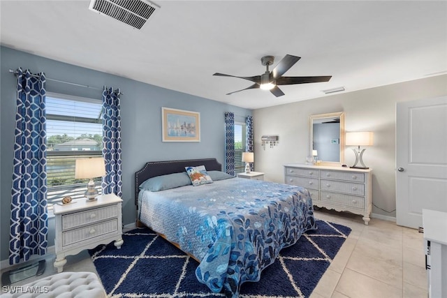 bedroom featuring ceiling fan, multiple windows, and light tile patterned floors