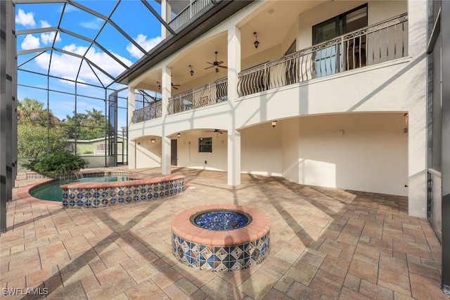 view of patio / terrace with a swimming pool with hot tub, a lanai, a balcony, and ceiling fan