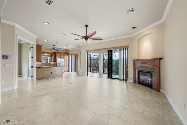 unfurnished living room featuring crown molding, ceiling fan, and a high end fireplace