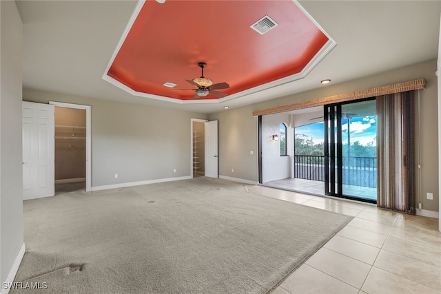 carpeted spare room featuring ceiling fan and a tray ceiling