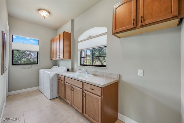 laundry room featuring cabinets, separate washer and dryer, sink, and light tile patterned floors