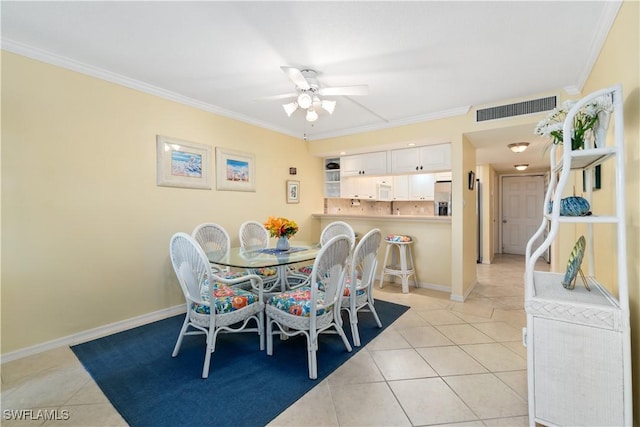 tiled dining room with crown molding and ceiling fan