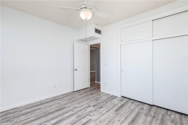 unfurnished bedroom with light hardwood / wood-style floors, a closet, and ceiling fan