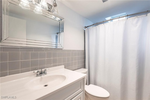 bathroom with vanity, tile walls, a shower with shower curtain, and toilet