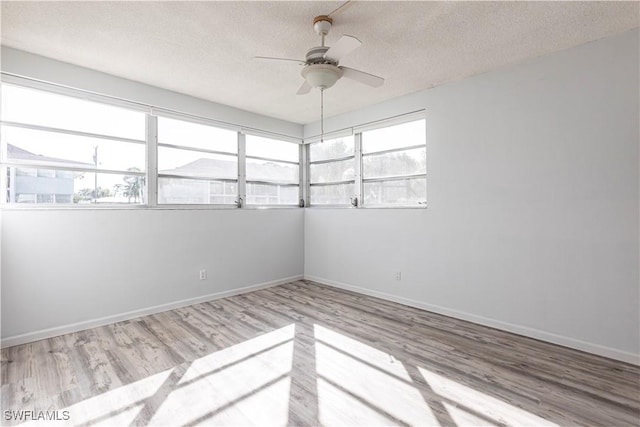 unfurnished room with ceiling fan, a textured ceiling, and light hardwood / wood-style floors