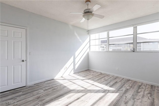 unfurnished room featuring ceiling fan, a textured ceiling, and light wood-type flooring