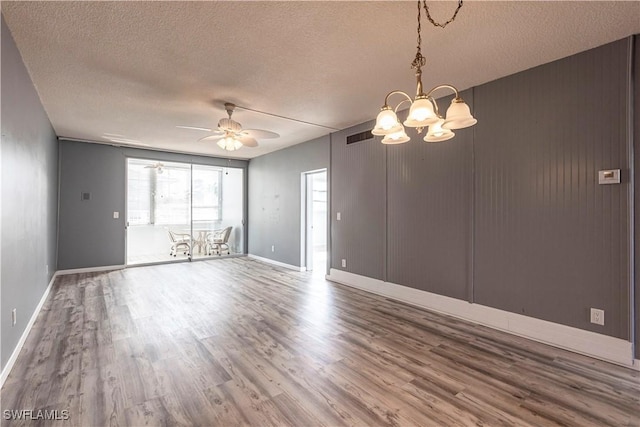 unfurnished room with hardwood / wood-style flooring, ceiling fan with notable chandelier, and a textured ceiling