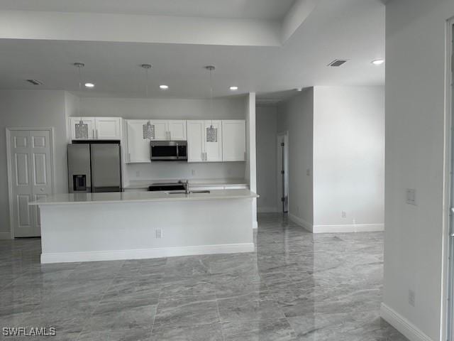 kitchen featuring appliances with stainless steel finishes, sink, a kitchen island with sink, and white cabinets