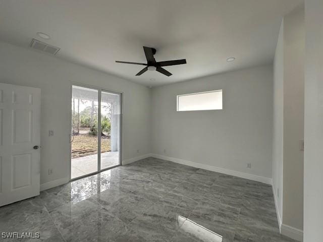 empty room featuring ceiling fan and a wealth of natural light