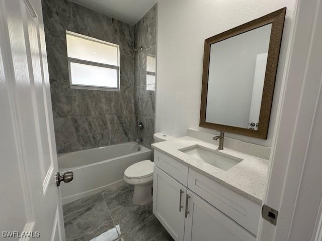 full bathroom featuring toilet, vanity, and tiled shower / bath