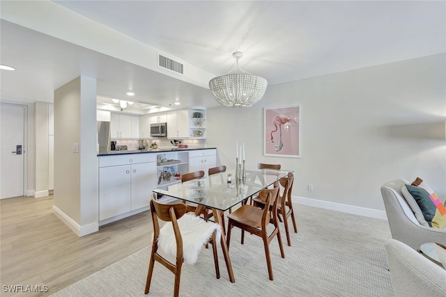 dining room featuring a notable chandelier and light hardwood / wood-style floors