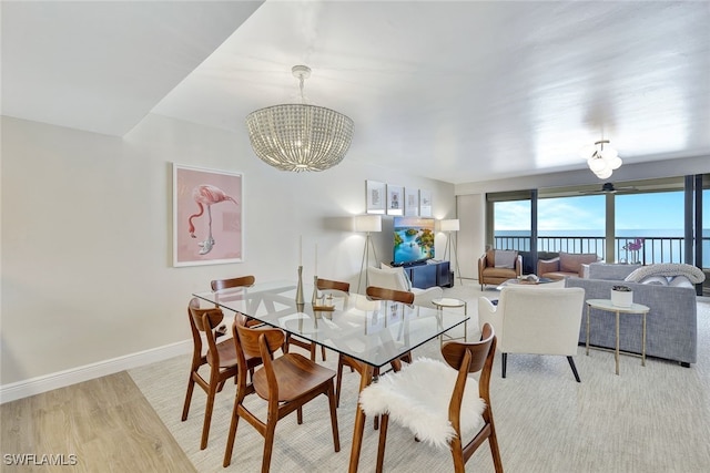 dining space with light wood-type flooring and an inviting chandelier