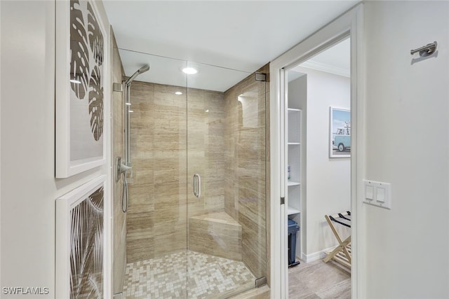 bathroom featuring ornamental molding and an enclosed shower