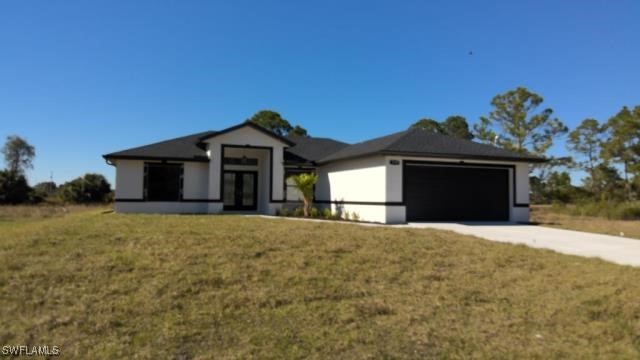 view of front of home with a garage and a front lawn