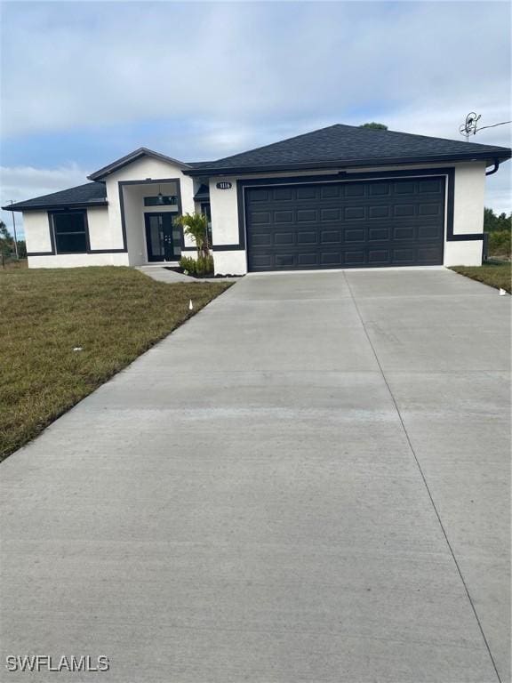 view of front of home featuring a garage and a front lawn