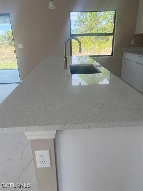 kitchen with sink and light stone countertops