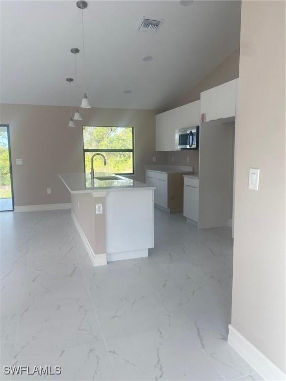 kitchen featuring pendant lighting, sink, white cabinets, a kitchen island with sink, and a healthy amount of sunlight