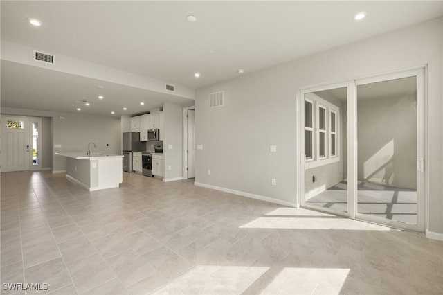 unfurnished living room featuring recessed lighting, visible vents, and baseboards