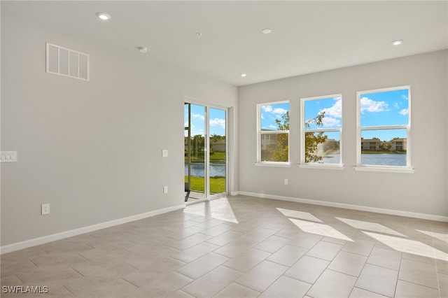 unfurnished room featuring light tile patterned floors, recessed lighting, visible vents, and baseboards