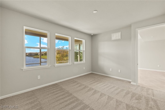 empty room with baseboards, carpet flooring, and a water view