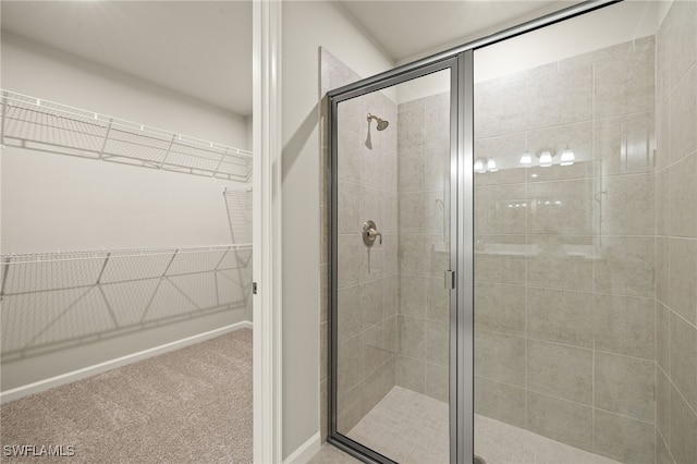 full bathroom featuring a shower stall and a walk in closet