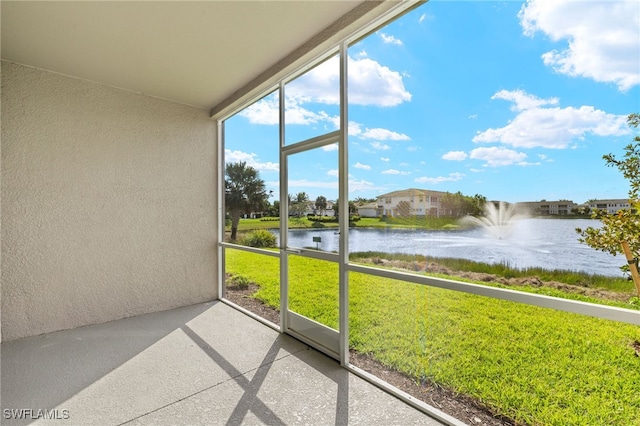 unfurnished sunroom featuring a water view