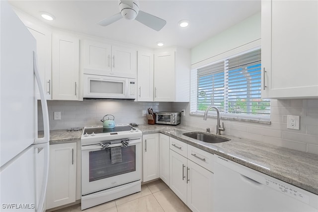 kitchen featuring white cabinetry, sink, backsplash, light tile patterned floors, and white appliances