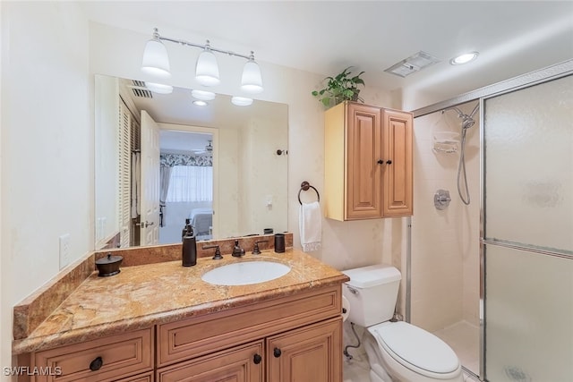 bathroom featuring vanity, toilet, and a shower with shower door