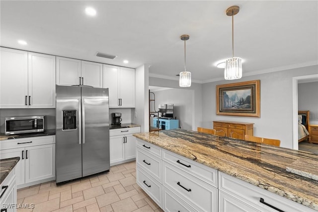 kitchen with crown molding, appliances with stainless steel finishes, white cabinetry, hanging light fixtures, and light stone countertops