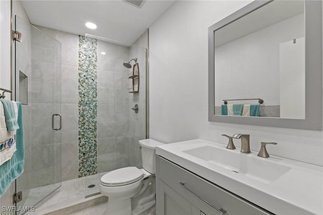 bathroom featuring vanity, an enclosed shower, and toilet