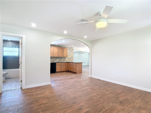 kitchen with kitchen peninsula, ceiling fan, decorative backsplash, dark hardwood / wood-style floors, and dishwasher