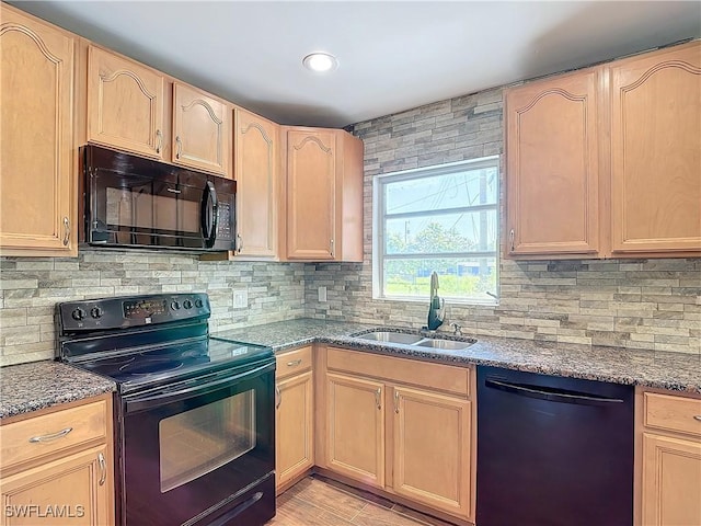 kitchen with black appliances, sink, light brown cabinets, and dark stone countertops