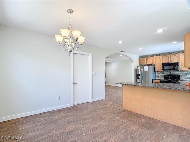 kitchen featuring black appliances, decorative light fixtures, dark wood-type flooring, dark stone countertops, and backsplash