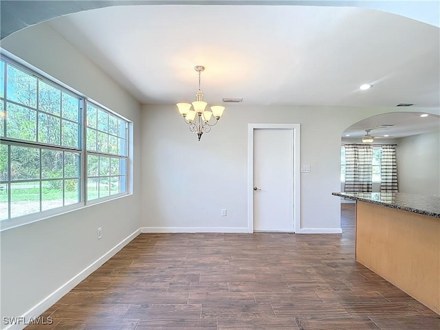 unfurnished dining area with dark hardwood / wood-style flooring and an inviting chandelier