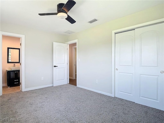 unfurnished bedroom with ceiling fan, sink, a closet, and carpet flooring