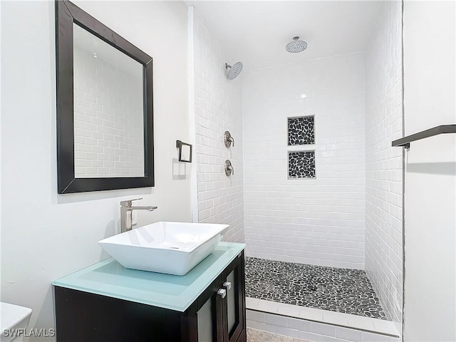 bathroom with vanity and a tile shower