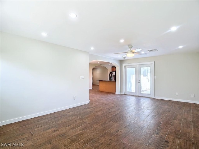 empty room featuring ceiling fan, french doors, and dark hardwood / wood-style flooring