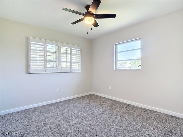 carpeted spare room featuring ceiling fan and plenty of natural light