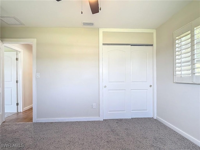 unfurnished bedroom with ceiling fan, a closet, and dark carpet