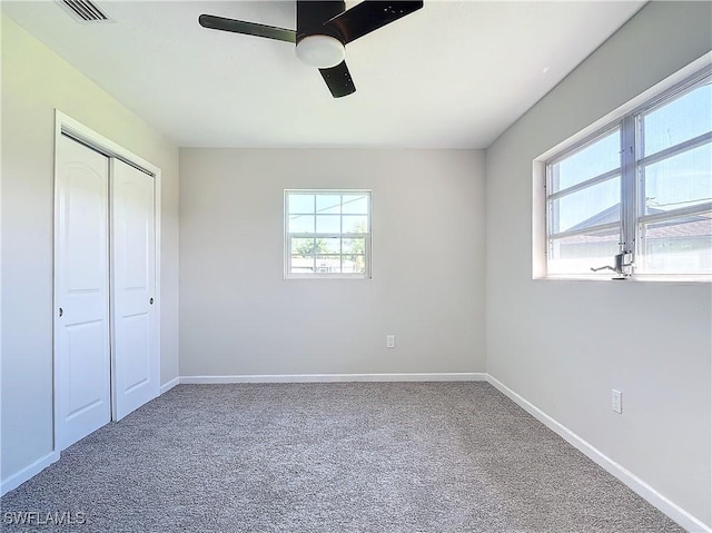 unfurnished bedroom with ceiling fan, a closet, and carpet flooring