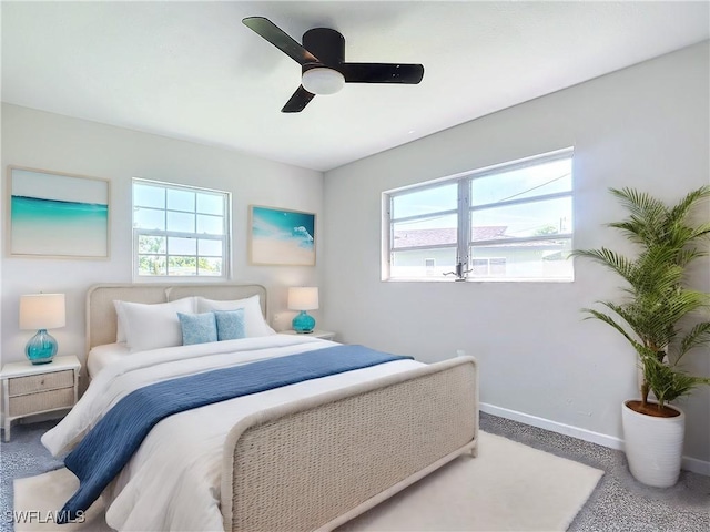 bedroom with ceiling fan and multiple windows