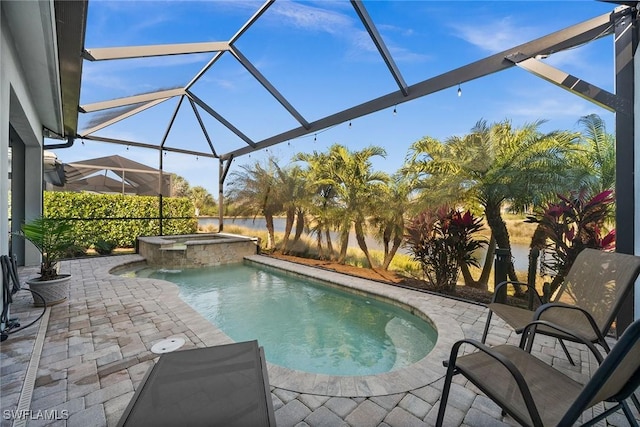 view of swimming pool featuring glass enclosure, an in ground hot tub, and a patio