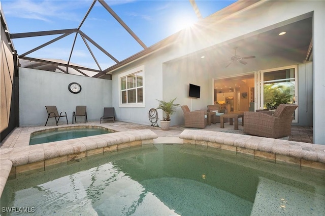 view of swimming pool with glass enclosure, a hot tub, a patio, ceiling fan, and an outdoor hangout area